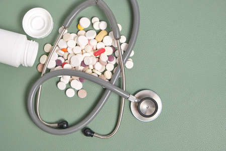 Stethoscope and a bunch of spilled expired pills