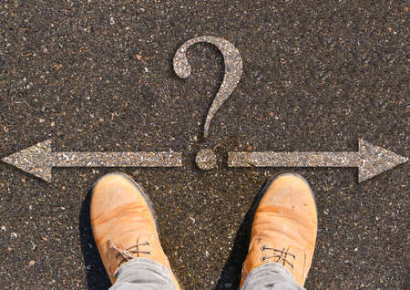 Human legs in batinki and two directions right and left with question mark.Concept fork in road and in lifeの写真素材