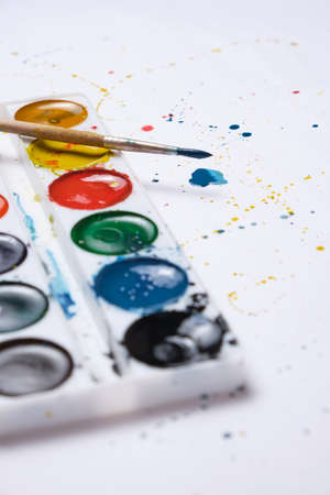 Set bright watercolor paint and a brush for watercolor painting with blots white backgroundの写真素材