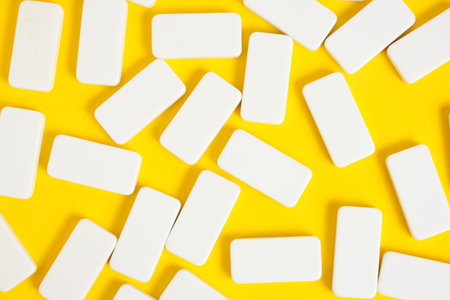 White domino blocks on a yellow backgroundの写真素材
