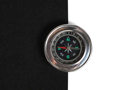 Compass on black and white background pointing west and eastの写真素材