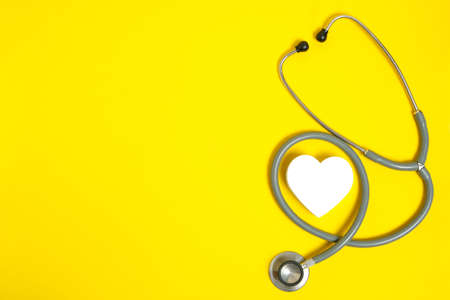 White heart and stethoscope on yellow background.Heart disease, medical examinationの写真素材