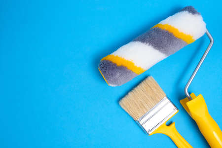 Paint roller and brush for painting and repairing walls on blue backgroundの写真素材