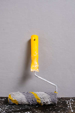 Paint roller for painting walls gray wall background