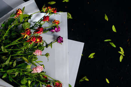 Discarded bouquet of decorative roses, dried flowers on a black backgroundの写真素材