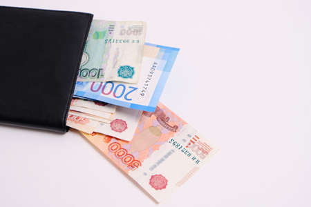 Russian rubles in denominations of one, two and five thousand rubles in a purse on a white backgroundの写真素材