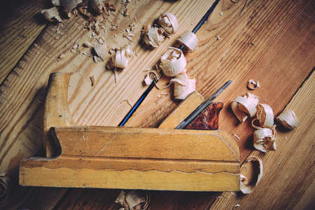 Old wooden carpenters tool plane on a wooden backgroundの写真素材