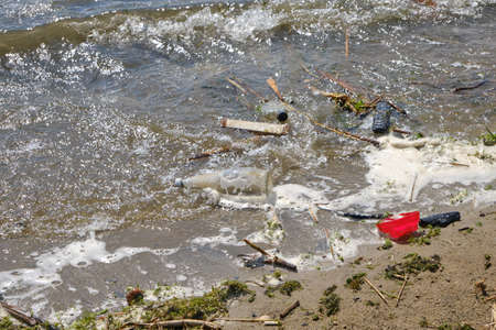 Garbage thrown out by waves beach, pollution of environment of human activity