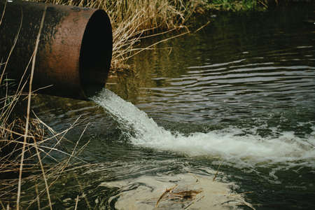 Draining sewage from pipe into river, pollution rivers and ecologyの写真素材