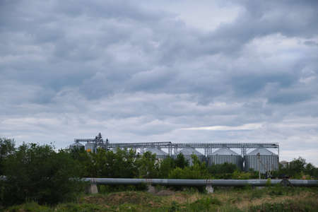 Grain elevator against the background of thickening gray clouds above itの写真素材