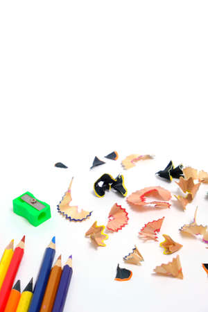 Sharpener and set colored pencils with wooden shavings white backgroundの写真素材