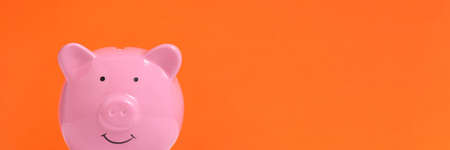 Banner,pink piggy bank on an orange backgroundの写真素材