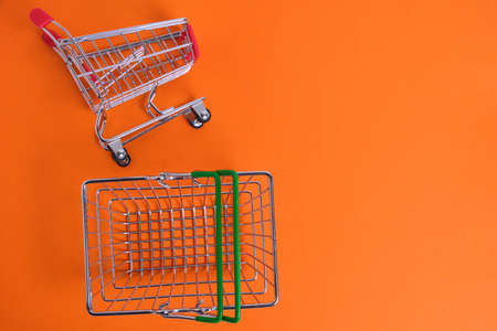 Cart and shopping basket orange background.Purchase concept and budgetの写真素材