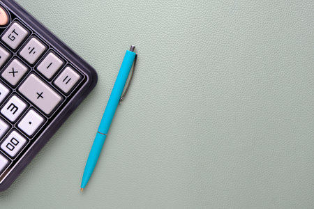Calculator with a ballpoint pen on a leather texture backgroundの写真素材