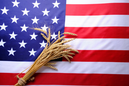 Flag of United States America and bunch wheat ears lying on it