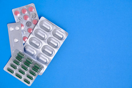 Lot of pills in package blue background. Concept shortage and rise in price medicines