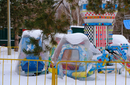 Snow covered, stopped and idle childrens rides in winterの写真素材