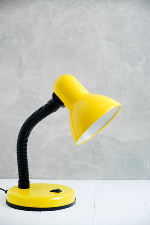 Bright yellow table lamp background concrete wall