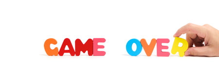 Man hand composes the word game over in letters on white background