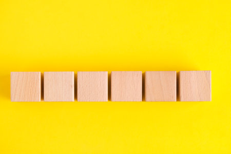 Beech wooden cubes yellow backgroundの写真素材