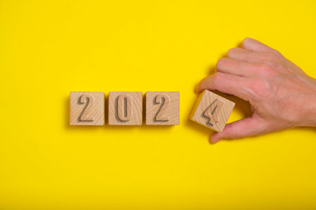 Wooden cubes with numbers 2024 yellow background are made by handの写真素材