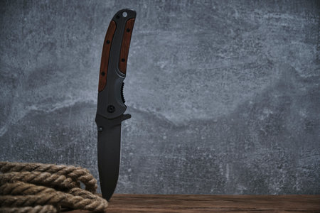 Survival knife and rope gray background