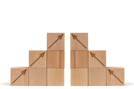 Pyramid of wooden cubes with arrows leading to top white background.Concept growth and developmentの写真素材