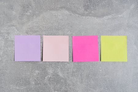 Colorful stickers for writing notes are glued concrete wall