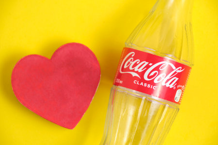 Kazakhstan, Kostanay, February 3, 2023, empty glass bottle Coca Cola classic and red heart yellow...