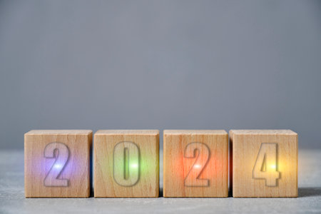 Inscription 2024 on wooden cubes glows in different colorsの写真素材