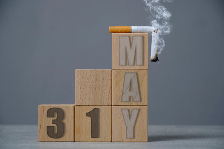 May 31, a smoking cigarette on top wooden cubes.Concept for tobacco free dayの写真素材