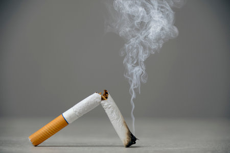 Broken smoking cigarette gray background