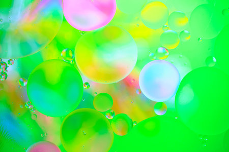 Multi colored abstract background with oil circles on water surface with a green background