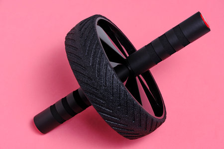 Sports simulator roller for press on pink background