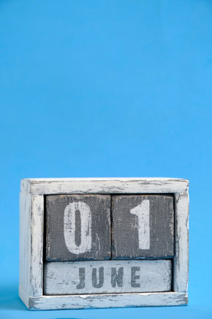 Calendar for June 01 made wooden cubes standing blue background. With empty space for textの写真素材