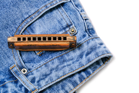 Harmonica, musical instrument, lies on denim pantsの写真素材