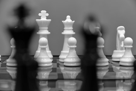 White chess pieces against background black blurred chess piecesの写真素材
