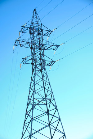 Metal support power line against blue sky