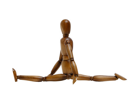 Wooden brown mannequin does twine and leg stretching.Concept of sportsの写真素材