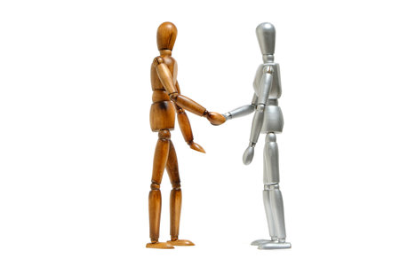 White and dark skinned mannequins greet each other by shaking handsの写真素材