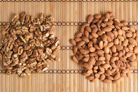 Peeled walnuts and almonds are laid out bamboo substrateの写真素材
