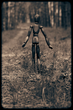 Wooden mannequin wandering along path forest.Creepy coverの写真素材
