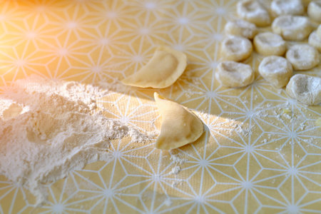 Dumplings and dough for cooking in flour on tableの写真素材