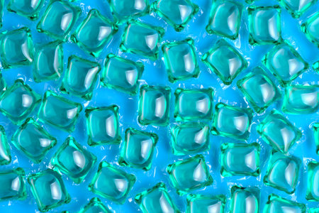 Background lot of capsules for washing green on blue background