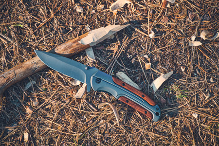 Folding hunting knife for survival and sharpened peg lie ground