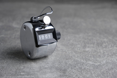 Metal, retro mechanical hand counter gray concrete backgroundの写真素材