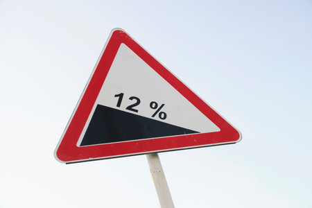 Warning road sign with road slope twelve percent