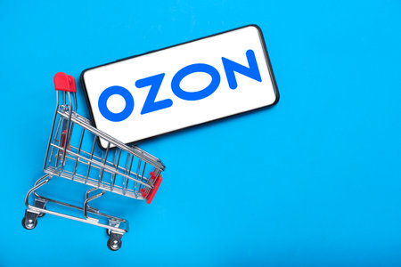 Kostanay, Kazakhstan, August 31, 2023. OZON is largest Russian online retailer.Smartphone with OZON logo,shopping basket blue background.Concept online shopping.のeditorial素材