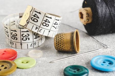 Sewing kit of needle, thimble, thread and measuring meter.On gray concrete table topの写真素材