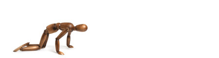 Wooden dummy crawls its knees towards goal.On white backgroundの写真素材